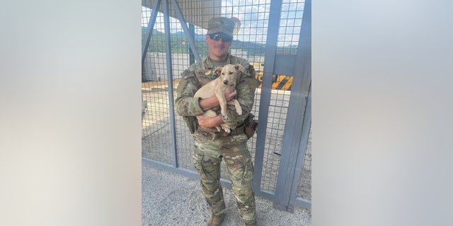 U.S. Army Specialist Howe holds his rescue pup, Doc.